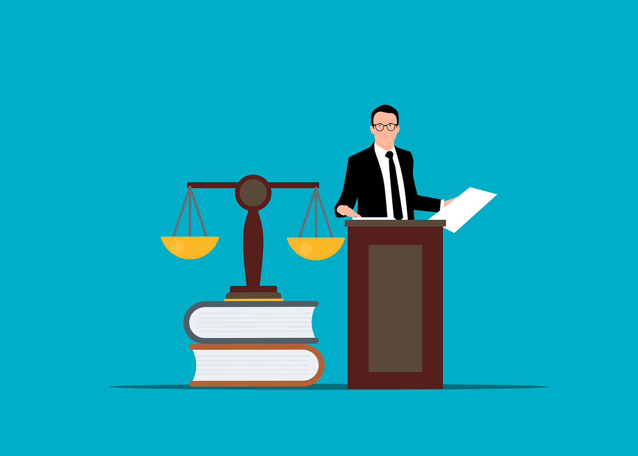 lawyer behind podium next to scales